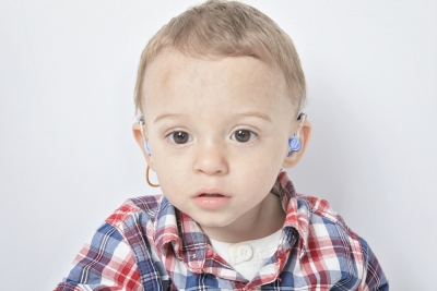 child-wearing-ear-gear-over-hearing-aid